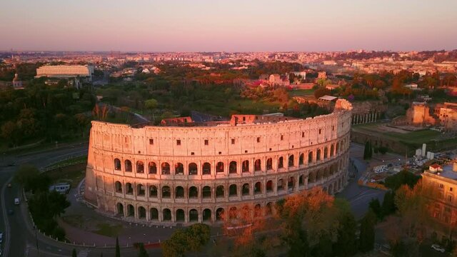 rome city centre colosseum monument aerial view at dawn,drone flying orbit around the italian landmark,historic downtown in the background