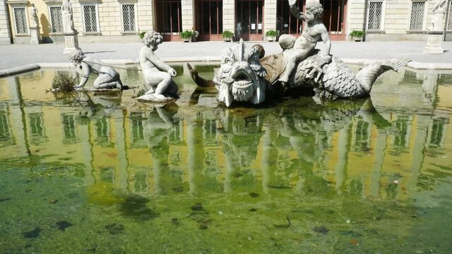 The beautiful fountain of the famous "Villa Olmo" (meaning: Olmo's Villa), Como, Italy. The facade of the villa is on the background, with blue sky with white clouds.