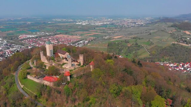 Beautiful top view of the Starkenburg castle in the German city of Heppenheim. The castle is high on the mountain. Mountains and the blue sky in the background. Tiled roofs of houses.