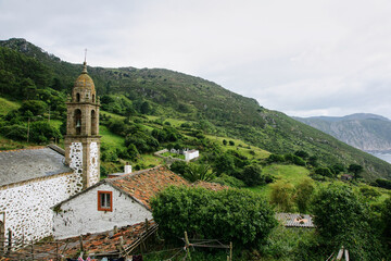 Rural landscape with an old church in the foreground and with the coast in the background