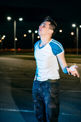 Guy at night in the parking lot against the background of lanterns