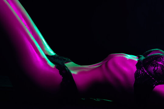 Slim thin female body in underwear. Sexy figure of a girl with neon lighting