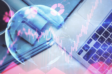 Business theme hologram drawings over computer on the desktop background. Top view. Multi exposure....