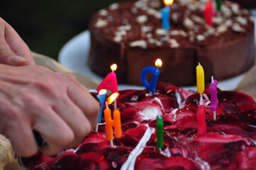Die zwei Geburtstagstorten selbstgebacken: die Kerzen auf dem Kuchen werden entzündet. 