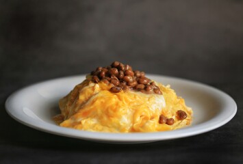 Omelette rice and Japanese fermented soybeans in the white plate