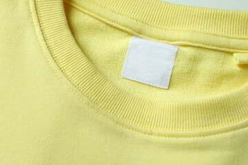 Yellow sweatshirt with blank label, close up