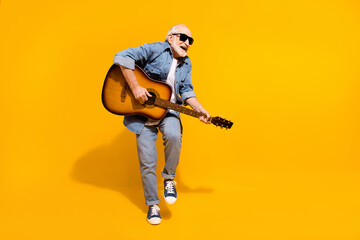 Full size photo of cheerful aged person hands hold playing guitar isolated on yellow color...