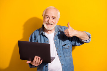 Photo portrait of elder man showing thumb-up like sign keeping laptop smiling isolated bright...