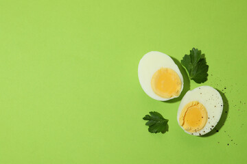 Tasty boiled eggs on green background, space for text