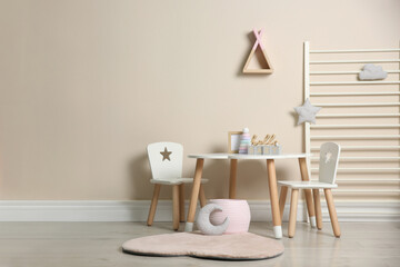 Baby room interior with stylish table, chairs and toys