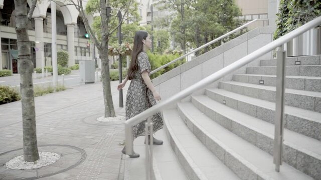 ワンピースを着て階段を上る女性