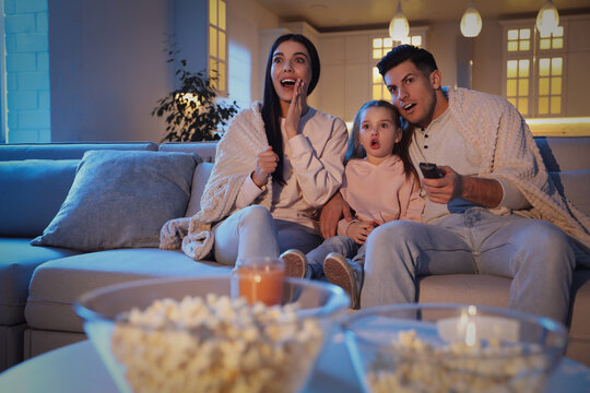 Family Watching Movie On Sofa At Night
