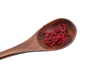 Saffron background. Close-up of red safran spice threads or strands in a rustic wooden spoon isolated on a white background. Clipping path.Macro.