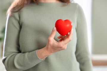 Young woman holding red heart, health insurance, donation, love concept