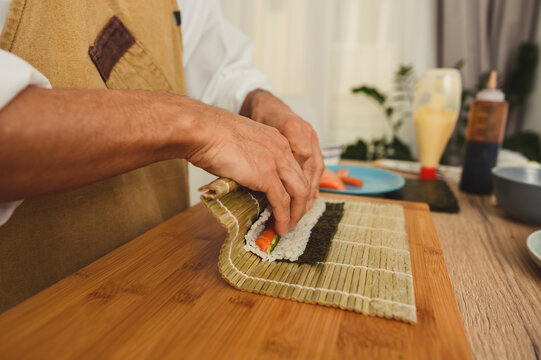 How to make sushi DIY courses. Close-up of chef hands preparing sushi rolling