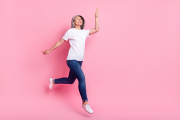 Fototapeta na wymiar Full length body size photo of elder woman jumping high greeting waving hand isolated pastel pink color background
