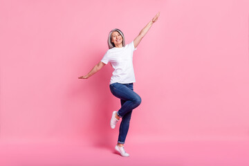 Photo of shiny funky age woman dressed white outfit smiling dancing jumping isolated pink color background