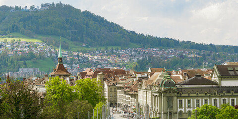 Panoramic view of Bern with mountain and tiled roofs on a sunny day, Switzerland