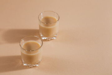 Short glasses of Irish cream Liquor or Coffee Liqueur on light background