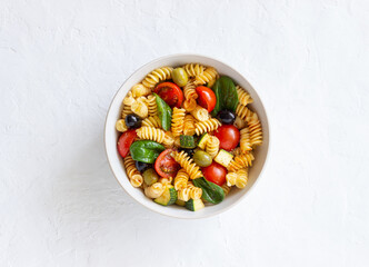 Pasta salad with tomatoes, zucchini, olives and spinach. Healthy eating. Vegetarian food.