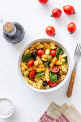 Pasta salad with tomatoes, zucchini, olives and spinach. Healthy eating. Vegetarian food.