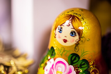 A traditional Russian Matryoshka, wooden nesting doll with a beautiful face, in gold, green,...
