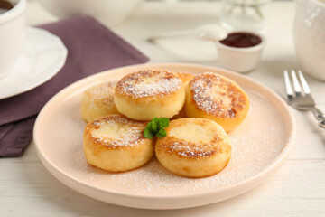 Delicious cottage cheese pancakes with mint and icing sugar on white wooden table