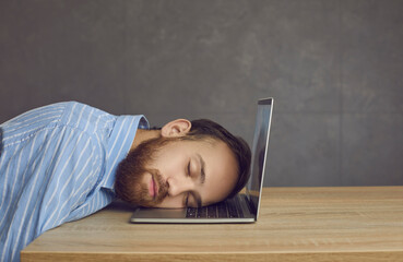 Tired business man office worker sleeping on laptop keyboard studio shot. Closeup side view...