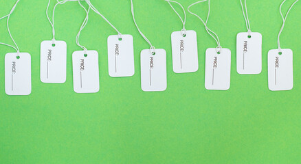 White price tags with copy space on a green background.