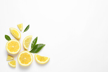 Flat lay composition with juicy lemon slices and green leaves on white background. Space for text