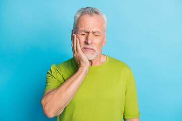 Portrait of attractive sick grey-haired guy touching cheek feeling tooth ache isolated over bright...