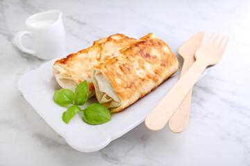 Tasty stuffed pancakes crepes with meat and sauce and basil. Food photography.