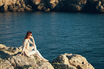 woman in summer on the beach near the sea in the mountains on nature landscape