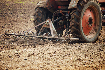 plow tractor plows the land for planting agricultural plants. the farmer cultivates the land in the spring for sowing seeds. iron plow of the mechanized machine