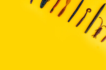 Bass fishing concept on the yellow trendy background. Flat lay style. Fishing tackle, soft silicon...
