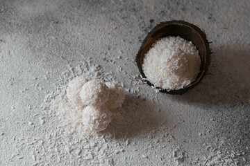 Coconut healthy sugarfree balls in coconut shells with coco flakes on light gray white background