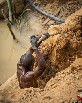 Black Man Digging The Ground With A Shovel In A Diamond Mine