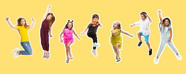 Group of elementary school kids or pupils jumping in colorful casual clothes on yellow background. Collage.