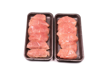 Turkey fillet in a black plastic container isolated.
