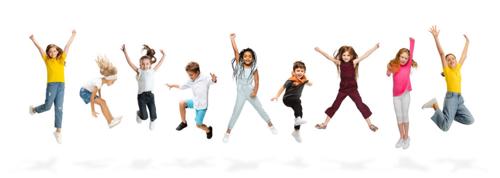 Group of elementary school kids or pupils jumping in colorful casual clothes on white studio background. Creative collage.