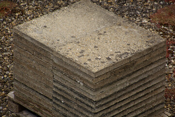 Old gray concrete walkway plates stacked on palett close-up view