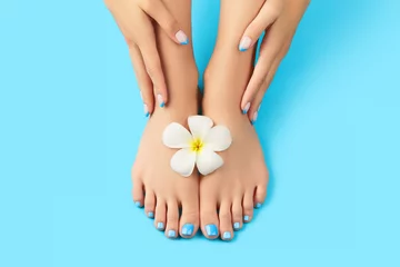 Foto op Canvas Manicure, pedicure schoonheidssalon concept. Dames voeten op blauwe achtergrond © Darya Lavinskaya