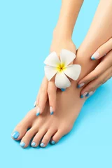 Foto op Aluminium Manicure, pedicure schoonheidssalon concept. Dames voeten op blauwe achtergrond © Darya Lavinskaya