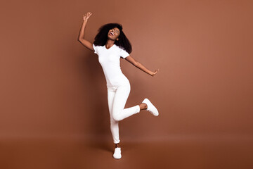 Fototapeta na wymiar Full size photo of young excited black girl happy positive smile have fun dance isolated over brown color background