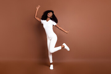 Full size photo of young excited black girl happy positive smile have fun dance isolated over brown...