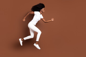 Fototapeta na wymiar Full length body size side profile photo of cool funky model jumping up running fast isolated on pastel brown color background