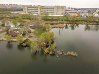Obraz premium City lake shore in cloudy weather. Aerial drone view.