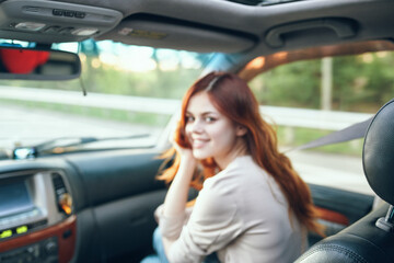 Fototapeta na wymiar woman fellow traveler in a car salon in the front seat design open window nature