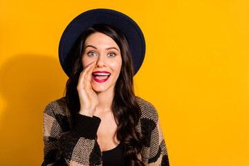 Photo of happy young woman hold hand mouth whisper secret empty space isolated on yellow color background