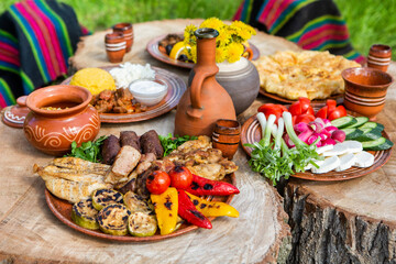 Homemade Romanian Food with grilled meat, polenta and vegetables Platter on camping. Romantic...